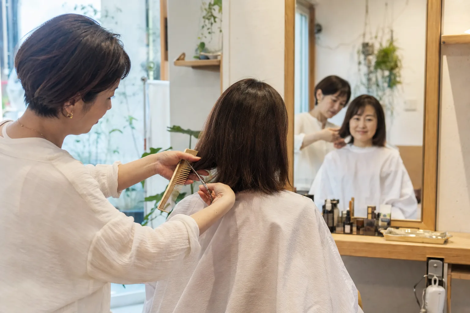 美容室でカット施術を行うスタイリスト